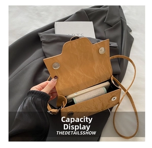 Detail shot of the small crossbody bag interior showing phone capacity and magnetic snap