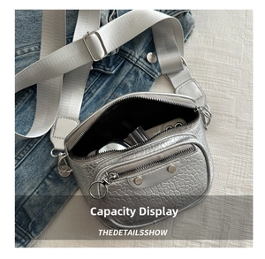 Detail of silver crocodile pattern bag interior showing capacity for makeup and phone
