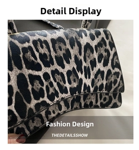 Detail of leopard print embossed leather handbag featuring distinctive curved wave base