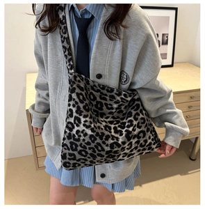 Detailed view of the leopard print tote bag worn on shoulder in a minimalist room