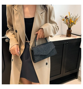 Sac carré à paillettes noires étincelantes avec chaîne dorée porté par un mannequin