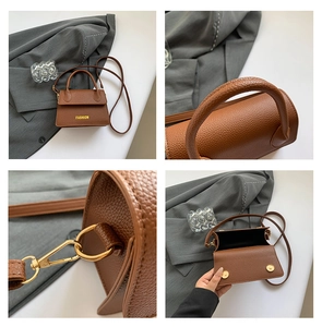 Detail view of lychee texture leather, metal hardware, and interior of the brown handbag
