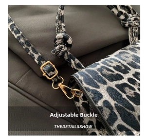 Detail of leopard print handbag showing golden adjustable buckle and spring hook texture