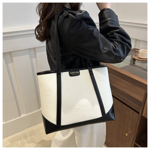Detail of contrast color tote bag with lychee grain texture and fashion bag patch