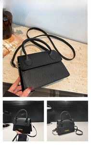 Detail of black lychee grain leather handbag featuring yellow fashion lettering and flap