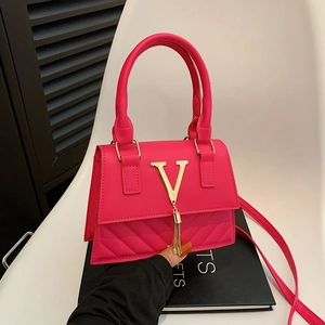 Hot pink crossbody bag with gold V-logo and fringe tassel, stylish minimalist purse