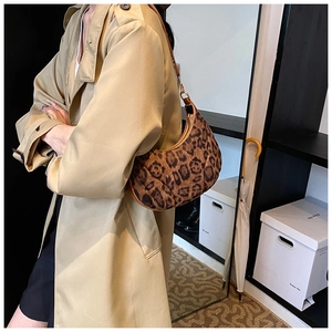 Detail showing leopard print crescent shoulder bag with retro velvet texture and metal hardware