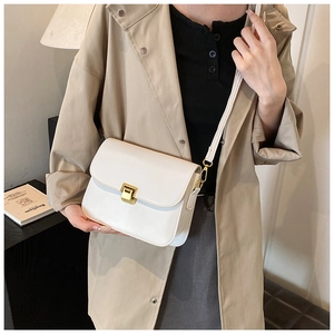 Detailed shot of white leather crossbody bag with elegant gold metal lock and leather strap