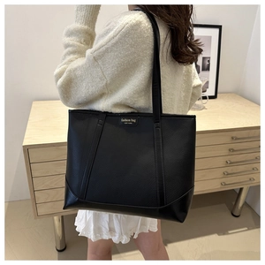 Detail of black pebbled leather tote with fashion bag NEW YORK gold lettering