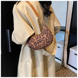 Detail of leopard print crescent bag with brown leather strap and metal buckle