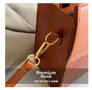 Detail of premium gold-toned metal hook and crocodile pattern leather on brown handbag