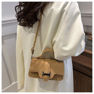 Detail view of khaki crossbody bag with pleated texture and stylish metal buckle