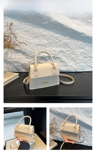 Close-up of white lychee textured PU leather small square bag with golden FASHION logo