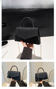 Detail of black glitter crossbody bag with top handle and golden chain shoulder strap