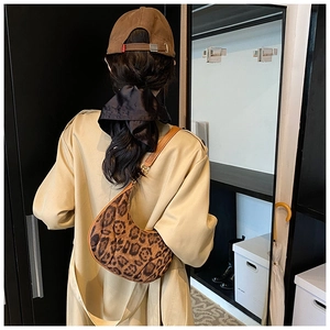 Leopard print hobo bag with leather strap styled with a trench coat on model shoulder