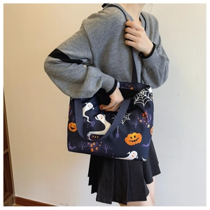 Detail of Halloween tote bag with pumpkin and ghost prints on navy blue fabric
