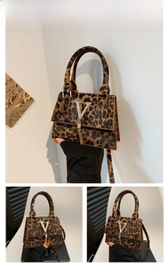 Dettaglio borsa leopardata con logo a V dorato e ciondolo con nappe decorative