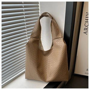 Detail of the intricate woven texture and leather craftsmanship on the khaki hobo tote bag