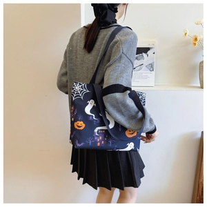 Model wearing Halloween tote bag with ghosts, pumpkins and castle prints in dark blue