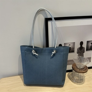 Sac fourre-tout en toile bleue avec anses en corde tressée argentée sur bois