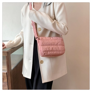 Detail of pink quilted shoulder bag with adjustable strap and soft nylon texture