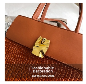 Close-up of brown crocodile embossed leather and decorative gold metal buckle