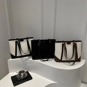 Three large minimalist tote bags in contrast colors on a display for autumn fashion