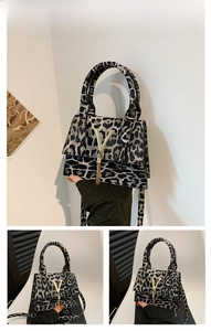 Dettaglio della borsa leopardata con fibbia a V dorata ed elegante ciondolo a nappa