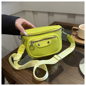 Detail of neon green cracked-leather crossbody bag with silver rivets and wide strap