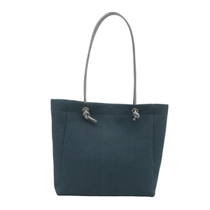 Minimalist navy blue denim tote bag with silver rope handles and metal eyelets on white back