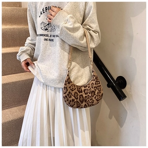 Close-up of leopard print hobo bag with adjustable brown strap and gold metal hardware