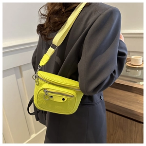 Detail view of neon green crocodile texture crossbody bag with silver metal studs