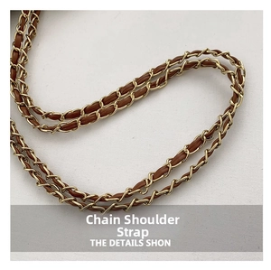 Detail of woven chain strap featuring brown leather and gold-tone metal hardware