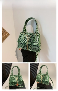 Dettaglio borsa leopardata verde con logo V dorato e nappina metallica raffinata