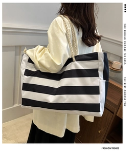 Close-up of striped canvas tote bag with woven rope handle and side pocket detail