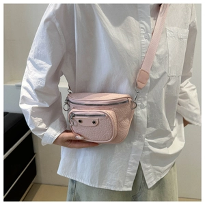 Detail of pink lychee leather crossbody bag with silver zippers and adjustable strap