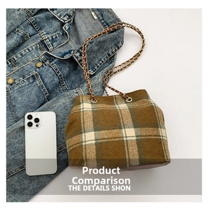 Close-up of wool plaid bucket bag with metal chain strap and leather trim detail
