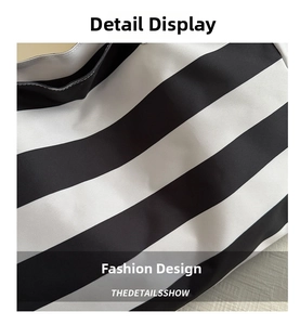 Detailed macro shot of black and white striped canvas texture and precise stitching on tote