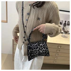 Detail showing high-quality leopard print fabric and knot handle of the shoulder bag