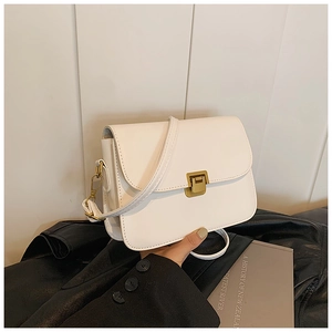 Close-up of white leather square bag with vintage gold buckle and slim shoulder strap