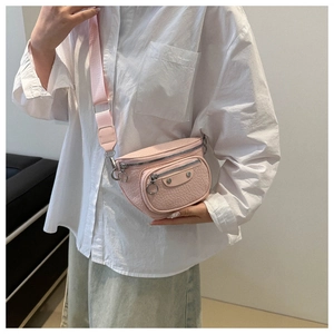 Detail of pink pebbled leather waist bag with silver hardware and wide nylon strap