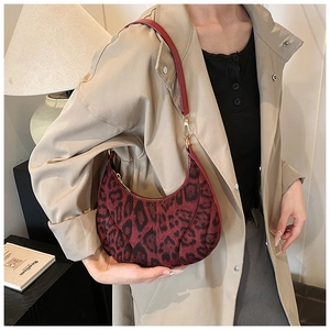Detail of red leopard print hobo bag with gold metal clasp and smooth velvet texture