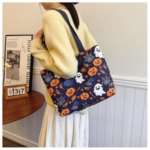 Detail of navy blue Halloween tote bag featuring pumpkin, ghost and witch hat patterns
