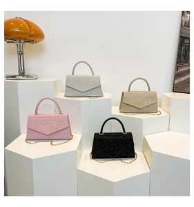 Detailed view of four glitter envelope evening bags in pink, silver, gold, and black finishes