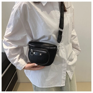 Detail showing black pebbled leather texture and silver rivet hardware on the crossbody bag