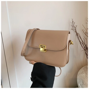 Detailed close-up of light brown crossbody bag with premium gold rectangular metal lock