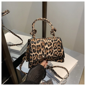Detailed view of leopard print handbag with knotted handle and unique curved base design