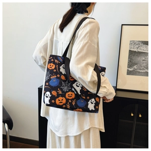 Lifestyle shot of Halloween tote bag with ghost and pumpkin prints on a shoulder model