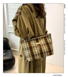 Detail of vintage plaid tote bag with gold chain strap and deer pendant on khaki coat