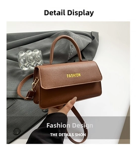 Close-up of brown lychee leather handbag with gold hardware and FASHION lettering